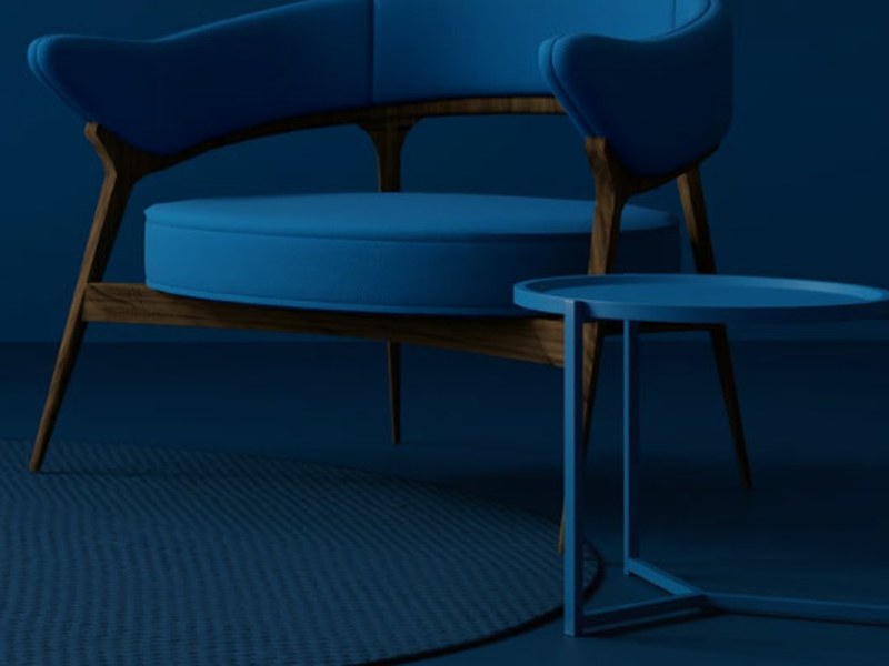 Wooden armchair with blue upholstery next to a side table in a blue room
