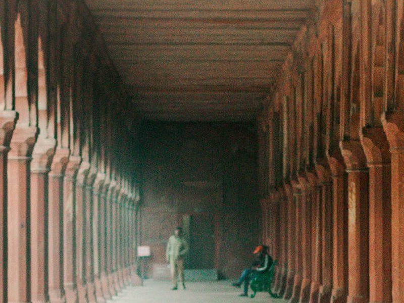 Colonnade of reddish stone columns in perspective
