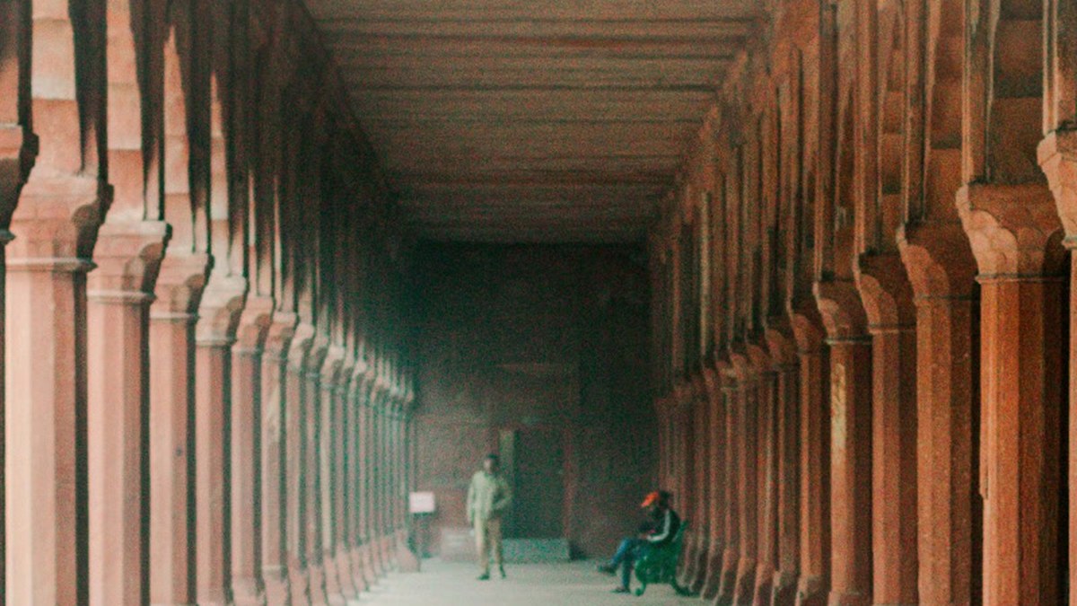 Colonnade of reddish stone columns in perspective